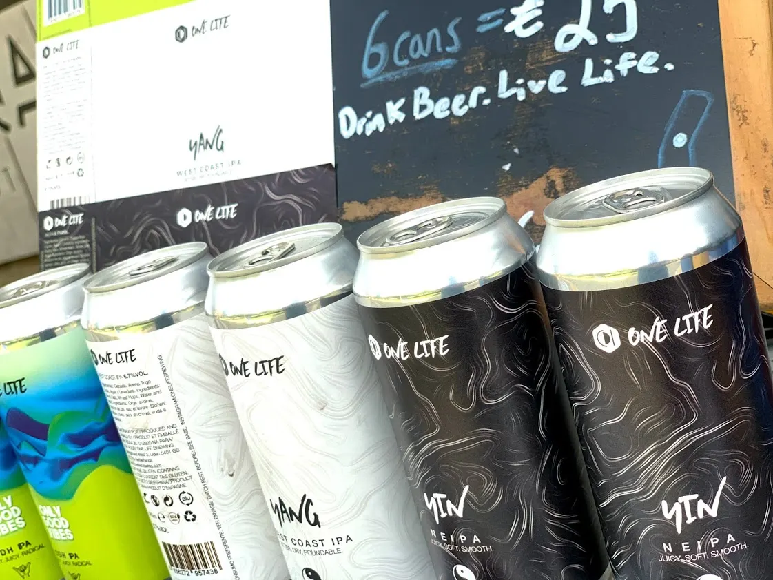 Archive photograph of 2019 One Life cans beside a branded case · 2019
